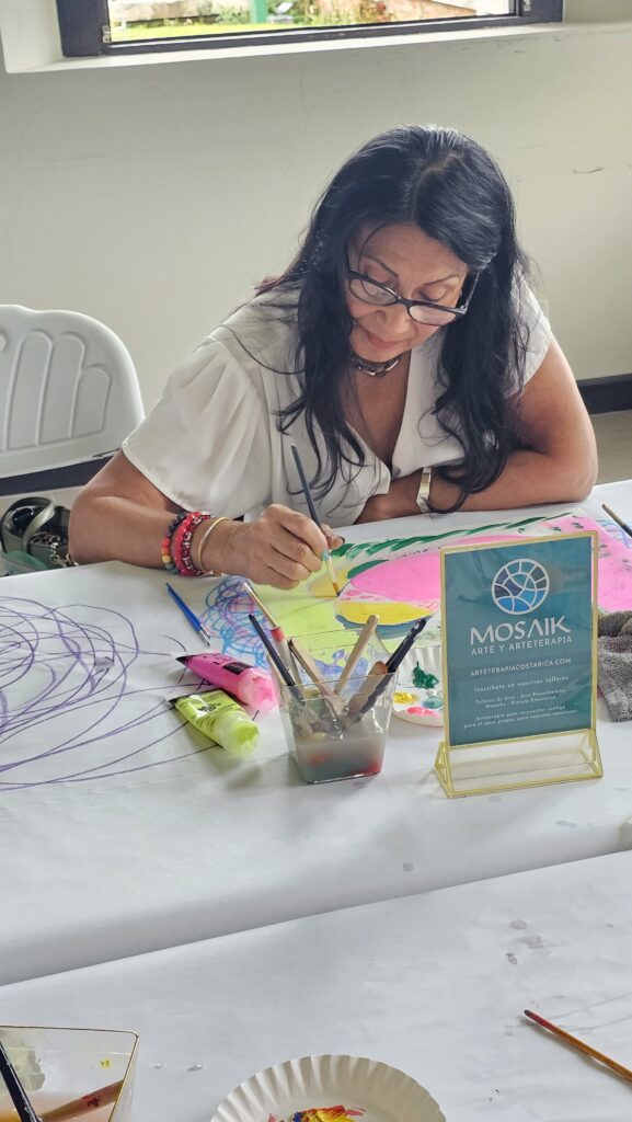 Participante explora formas y colores con pintura durante Puntos de Vida y Color Interno