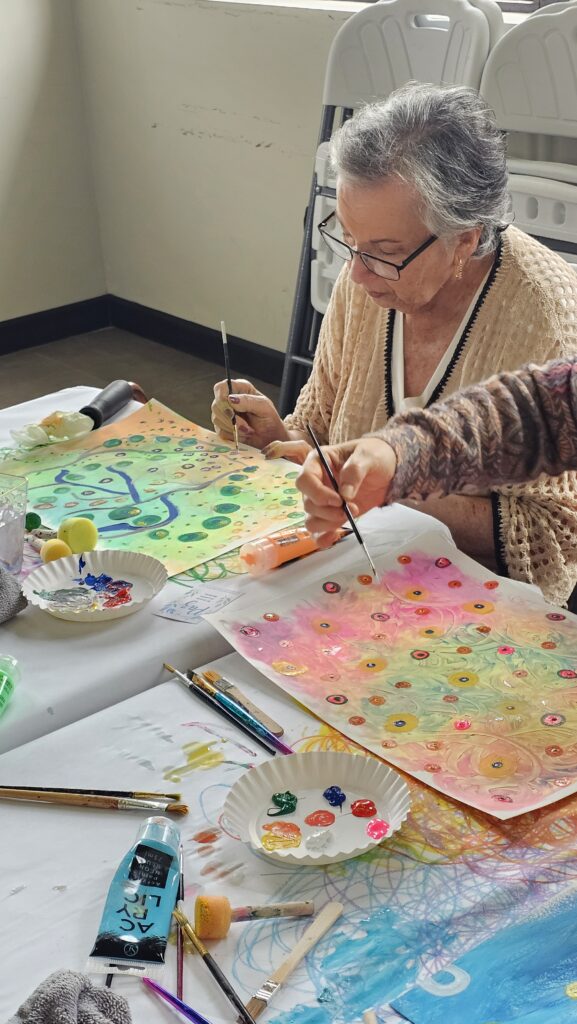 Participante trabaja con pincel color y puntos durante una experiencia de arteterapia MOSAIK