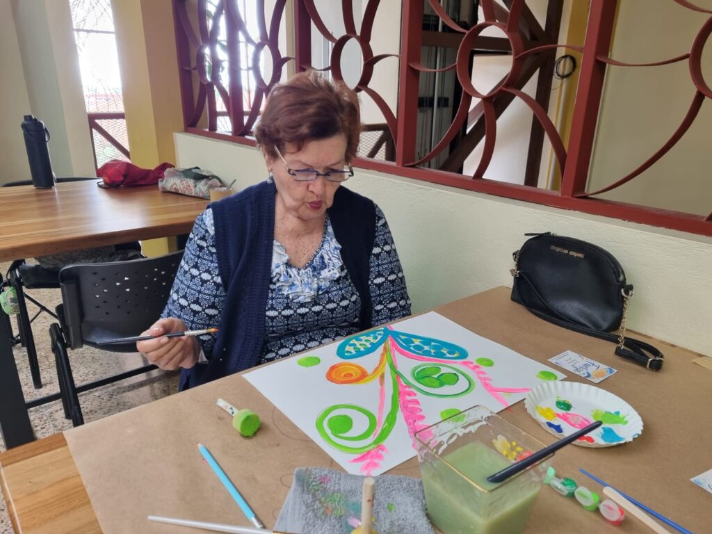 Manos pintando una composición durante la experiencia de arteterapia Mi camino mi color